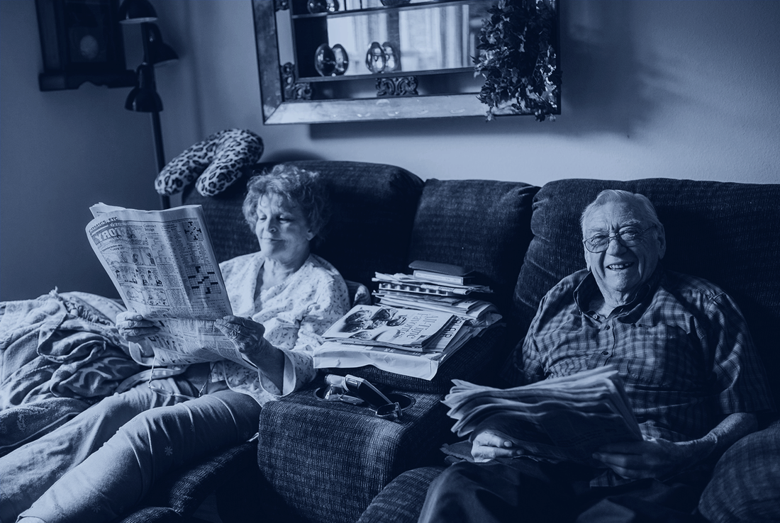 Elderly couple reading the newspaper - blue tint